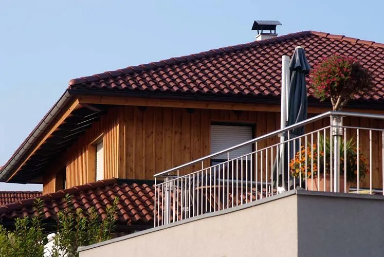 Wohnhaus mit Ziegeldach und Balkongeländer