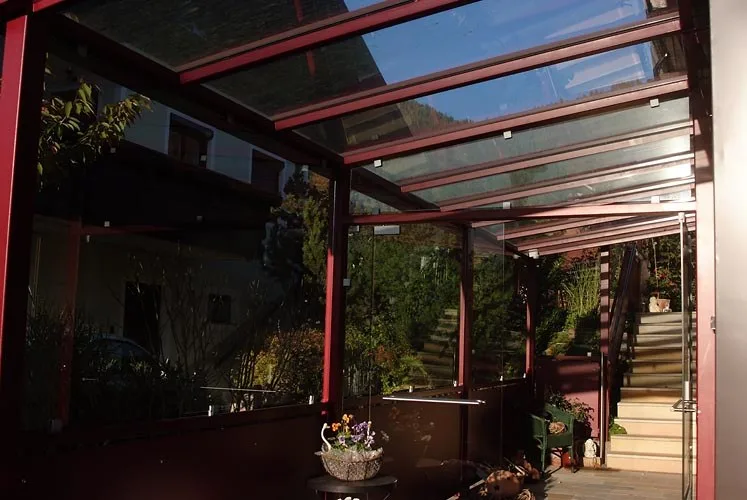 Rote Terrassenüberdachung an einem Wohnhaus