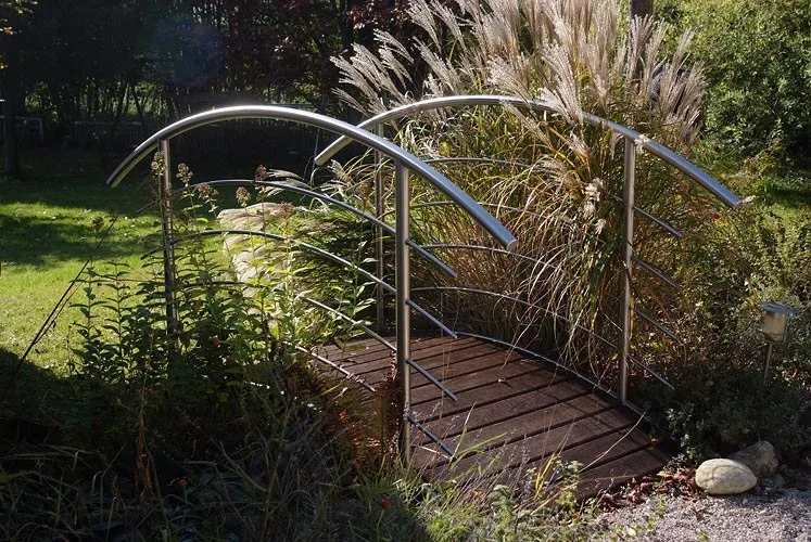 Kleine Brücke aus Metall in einem Garten